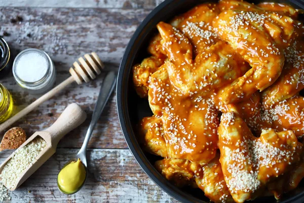 Pişirmeden önce tavada marine edilmiş çiğ tavuk kanadı. Tavuk kanadı pişiriyorum. Bufalo kanadı tarifi. Keto Paleo. Pegan.