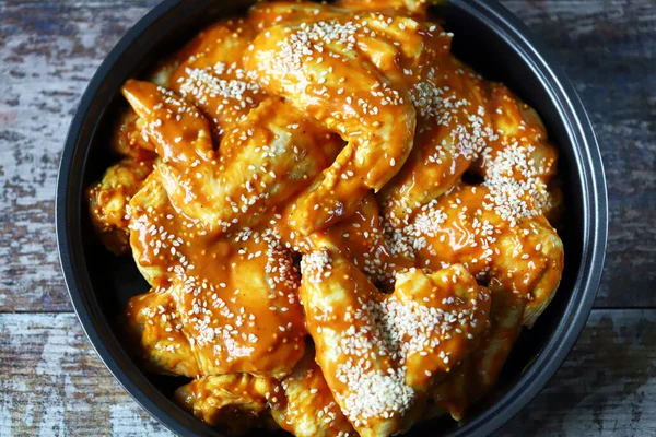 Susam sosunda marine edilmiş çiğ tavuk kanadı..