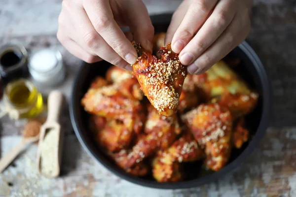 Adam tavuk kanadı yiyor. Kızarmış tavuk kanadı..