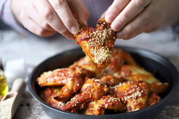 Adam tavuk kanadı yiyor. Kızarmış tavuk kanadı..