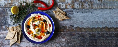 Bir tabak humus. Zeytin ve kırmızı biberli sağlıklı atıştırmalık humus. Vejetaryen atıştırması.