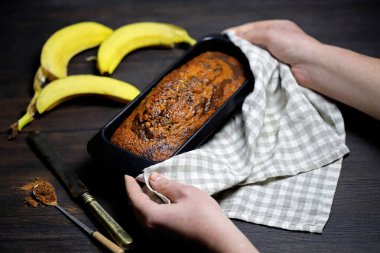 Ev yapımı muz ekmeği erkeklerin elinde bir kabın içinde..