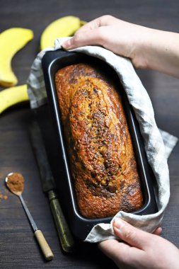 Ev yapımı muz ekmeği erkeklerin elinde bir kabın içinde..