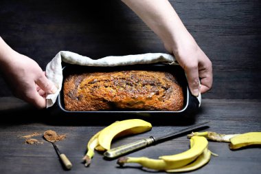 Ev yapımı muz ekmeği erkeklerin elinde bir kabın içinde..