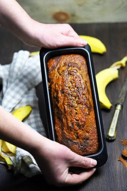 Ev yapımı muz ekmeği erkeklerin elinde bir kabın içinde..