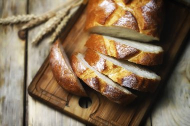 Seçici odaklanma. Tahtada taze buğday ekmeği var. Dilimler halinde ekmek.