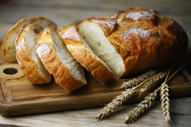 Seçici odaklanma. Tahtada taze buğday ekmeği var. Dilimler halinde ekmek.