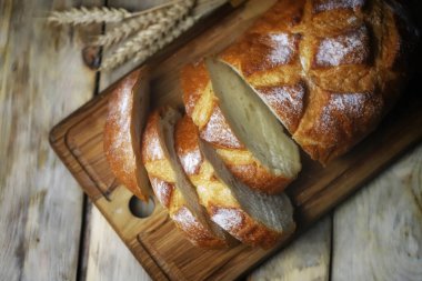 Seçici odaklanma. Tahtada taze buğday ekmeği var. Dilimler halinde ekmek.