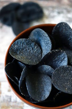 Bir kase siyah cips. Atıştırma modası. Siyah yemek..