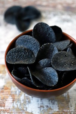 Bir kase siyah cips. Atıştırma modası. Siyah yemek..