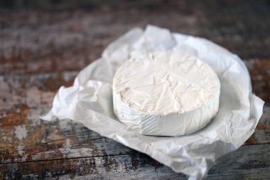 Beyaz kağıtta camembert peyniri. Taze Camembert peyniri.