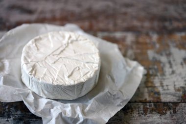 Beyaz kağıtta camembert peyniri. Taze Camembert peyniri.