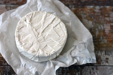 Beyaz kağıtta camembert peyniri. Taze Camembert peyniri.