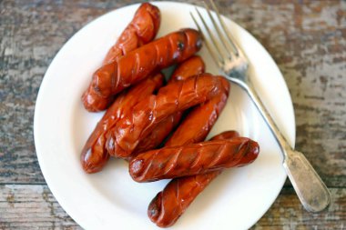 Beyaz tabakta ızgara sosis..