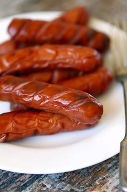 Beyaz tabakta ızgara sosis..