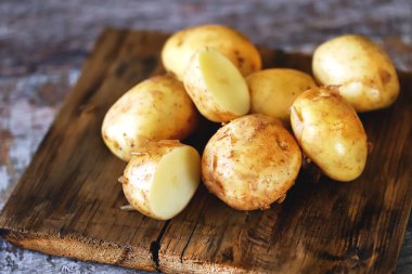 Tahta yüzeyde taze çiğ patates. Tahta yüzeyde taze çiğ patates..