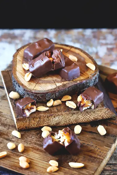 Fıstıklı çikolata ve ahşap arka planda karamel..