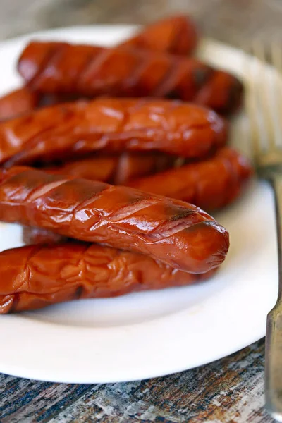 Beyaz tabakta ızgara sosis..