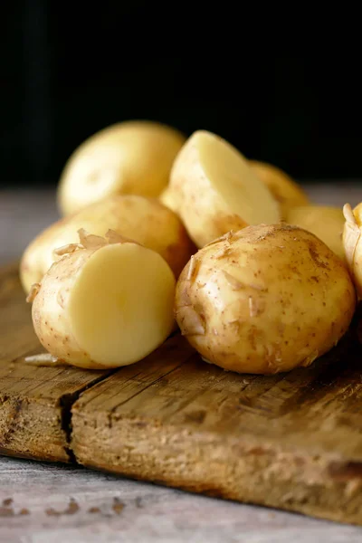 Fresh raw potatoes on a wooden surface.Fresh raw potatoes on a wooden surface.