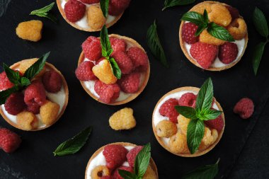 Beyaz yoğurtlu ahududu tartları ve taze ahududu. Sağlıklı bir tatlı. Keto tatlı..