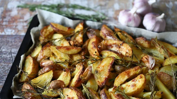 Fırında patates dilimleri iştah açıcı. Kır usulü patates kızartması. Bitki ve sarımsaklı patates..