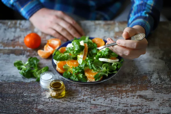 Mandalinalı, mozarellalı ve salatalı sağlıklı salata yiyen adam..