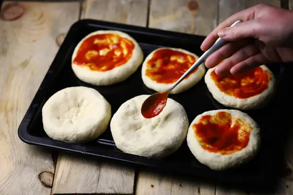 Mini pizza pişiriyorum. Fırın tepsisindeki mini pizzalar..