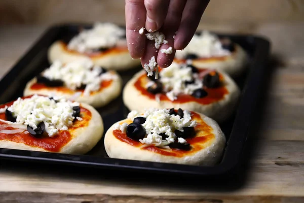 Mini pizza pişiriyorum. Fırın tepsisindeki mini pizzalar..
