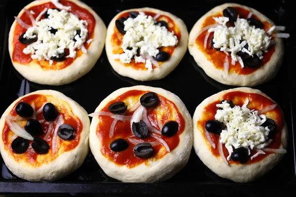 Mini pizza pişiriyorum. Fırın tepsisindeki mini pizzalar..