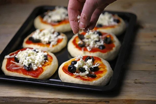 Mini pizza pişiriyorum. Fırın tepsisindeki mini pizzalar..
