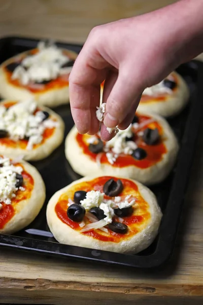 Mini pizza pişiriyorum. Fırın tepsisindeki mini pizzalar..