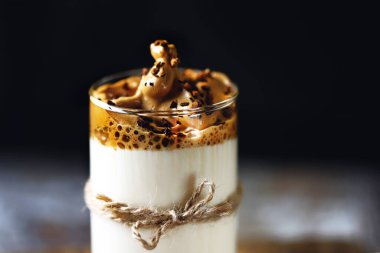 Dalgona kahvesi ahşap bir yüzeyde. Sağlıklı enerji kahvesi. Kokteyl eğilimi.