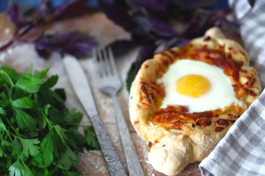 Tabağında yumurta ve otlarla Khachapuri..
