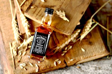 Jack Daniels viskisi. Ahşap arka planda 50 ml 'lik şişe. Buğday kulakları. Kharkiv Ukrayna 08 14 2020.
