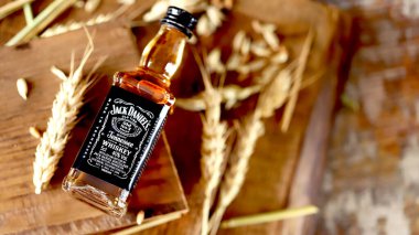 Jack Daniels viskisi. Ahşap arka planda 50 ml 'lik şişe. Buğday kulakları. Kharkiv Ukrayna 08 14 2020.
