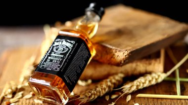 Jack Daniels viskisi. Ahşap arka planda 50 ml 'lik şişe. Buğday kulakları. Kharkiv Ukrayna 08 14 2020.