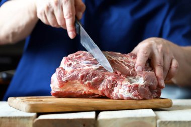 Şef tahtada çiğ et keser. Et pişiriyorum. Izgara için taze domuz eti..