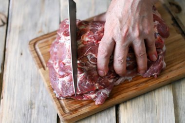 Şef tahtada çiğ et keser. Et pişiriyorum. Izgara için taze domuz eti..