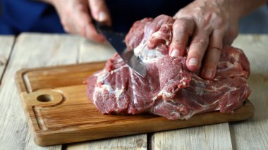 Şef tahtada çiğ et keser. Et pişiriyorum. Izgara için taze domuz eti..