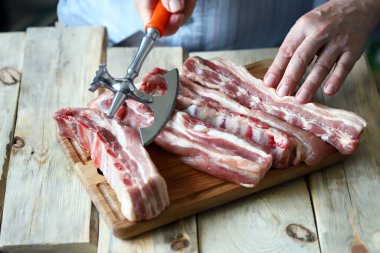 Et pişiriyorum. Şef domuz kaburgalarını baltayla kesiyor..