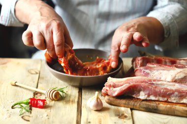 Şef çiğ pirzola marine eder. Izgara domuz pirzolası..