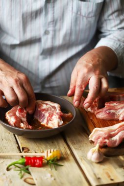 Şef çiğ pirzola marine eder. Izgara domuz pirzolası..