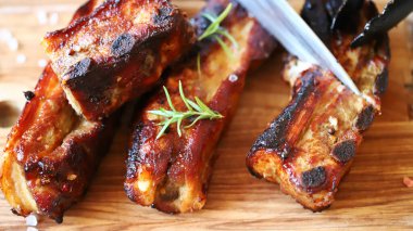 Ahşap bir tahtanın üzerinde domuz pirzolası. BBQ kaburgaları pişiriliyor..