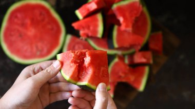 Ellerinde karpuz dilimleri. Karpuz hamuru. Dilimlenmiş karpuz parçalara ayrıldı..