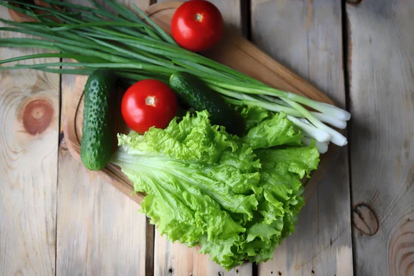 Marul, yeşil soğan, domates, salatalık. Tahtada taze sebzeler. Sağlıklı diyet kavramı.