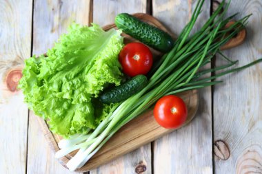 Tahtadaki yeşillikler. Yeşil soğan, salata, sebze. Sağlıklı beslenme. Salata ürünleri.