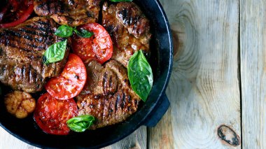 Seçici odaklanma. Tavada ızgara sebzeli, sulu ızgara biftek. Yakın plan..