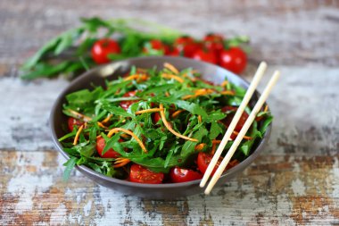 Roka, havuç ve vişneli domatesli sağlıklı salata kasesi..