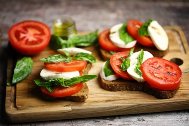 Seçici odaklanma. Tahtada Caprese tostu. İtalyan yemeği..