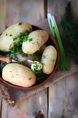 Kaynamış taze patates, içinde ot ve tereyağı var..